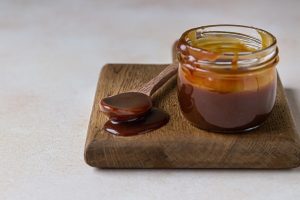 homemade caramel sauce in a glass jar delicious sauce with sea salt for ice cream and desserts - Карамельный соус