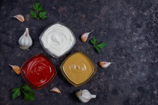 homemade ketchup mustard and mayonnaise sauce and ingredients on dark top view - Закрытые бутерброды