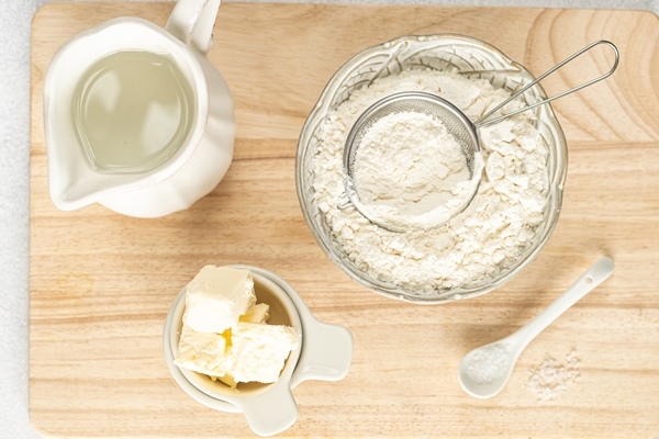 ingredients for home baking the concept of baking is a marble rolling pin flour butter water on a white background top view - Форшмак с телятиной