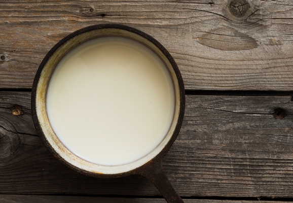 overhead view of fresh milk in an old saucepan over the wooden table - Суп-пюре из фасоли с молоком