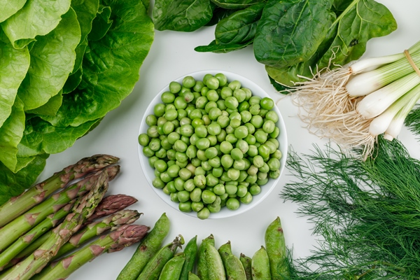 peas with lettuce asparagus green pods and onion dill sorrel in a white bowl on white wall top view - Салат из крабов