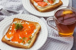 sandwiches or tapas of bread red caviar and red fish with micro greens seafood luxury delicacy food - Бутерброды на поджаренном хлебе