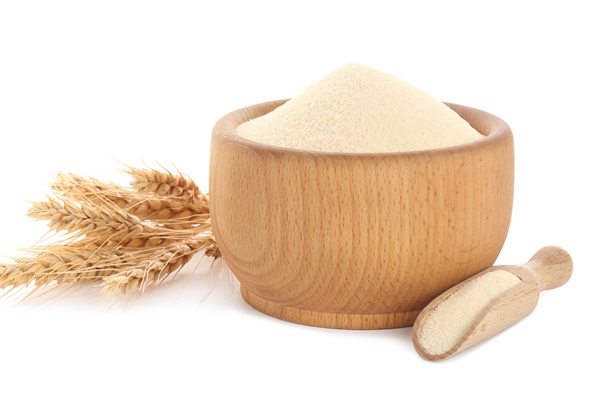 semolina in wooden bowl and scoop on white background - Творожный пудинг со шпинатом