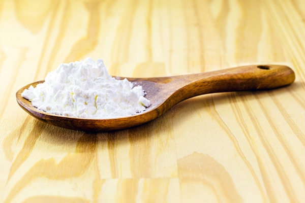 spoon with cornstarch flour made from corn used to make creams or as a thickener copy space - Суп из клюквы и яблок со сметаной