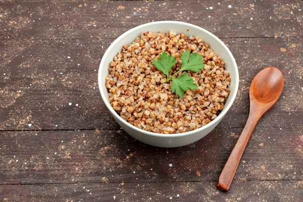 top view cooked tasty buckwheat inside plate on dark - Гречневая каша с молоком