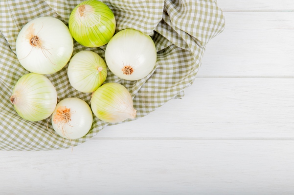 top view of white onions on plaid cloth and wooden background with copy space - Зразы из телятины