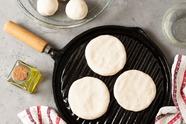 top view raw arepas on grill pan - Творожники ванильные со сметаной