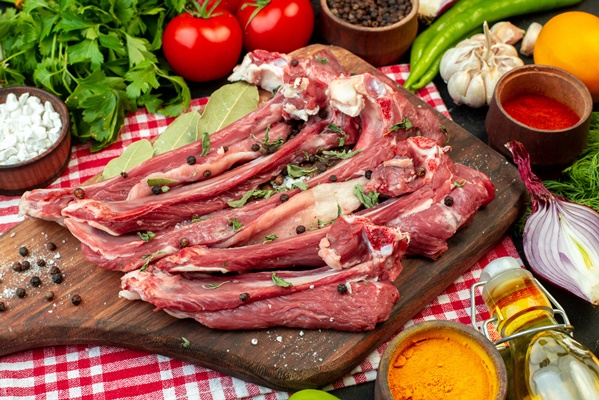 top view raw meat slices with greens and fresh vegetables on dark background meal meat butcher salad food cooking - Баранина тушёная с овощами