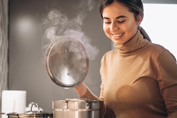 woman cooking at kitchen - Молочный суп с тыквой и рисом