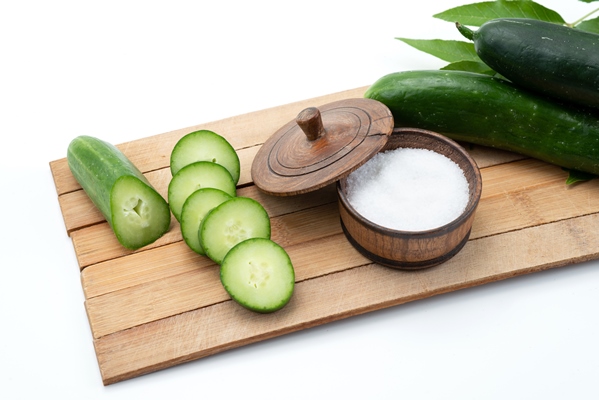 a front view sliced cucumbers with whole cucumbers and salt on brown wooden desk and white food meal - Постный огуречный суп без варки