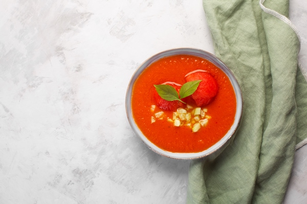 a plate of cold gazpacho puree soup traditional spanish dish of balanced tomato pepper and tabasco sauce on gray concrete background with olive towel - Томатный суп с зелёной гречкой