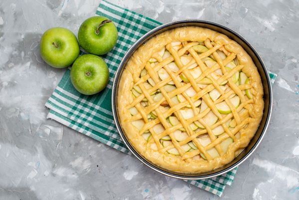 a top view delicious apple cake round formed inside pan with fresh green apples on the light desk cake biscuit - Сладкий дрожжевой пирог с ягодами