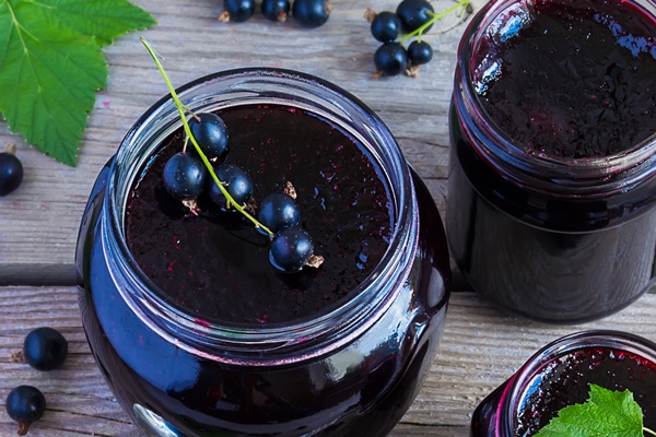 black currant jam on a wooden background view from above - Соус фруктово-ягодный