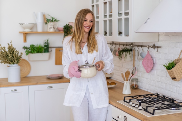 blonde pretty woman wearing white linen suit prepare food in her kitchen perfect house wife concept - Блинный торт с заварным кремом