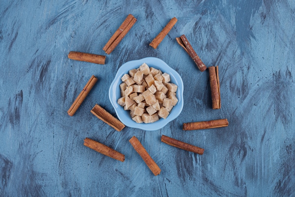 blue bowl of brown sugar cubes and cinnamon sticks on blue surface 1 - Монастырская кухня: оладьи из картофеля, жареные яблоки и сорбет (видео)