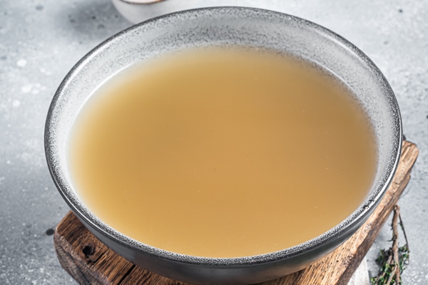 bone meat chicken broth in a plate gray background top view - Почки в луковом соусе
