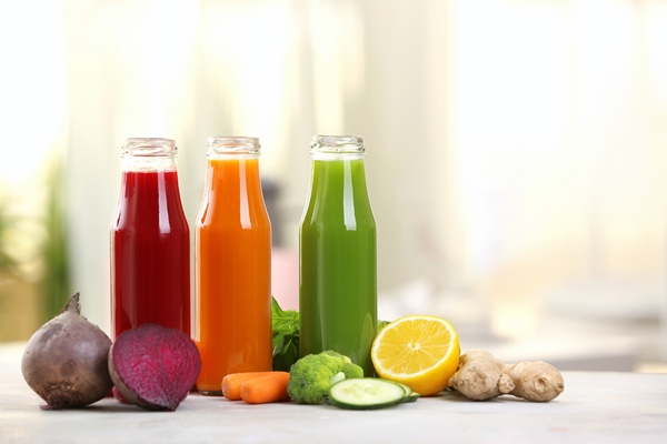 bottles with various fresh vegetable juices on table - Свекольный острый суп без варки