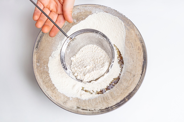 chef sifting flour through sieve - Блинчики с капустой