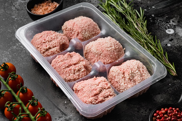 chicken burgers in retail container on black dark stone table background - Правила приготовления блюд из рубленого мяса
