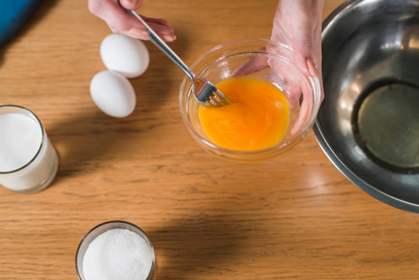 close up of woman s hand mixing the egg yolk with fork in the glass bowl - Шоколадный соус