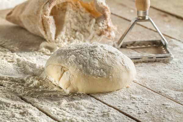 close up of wooden surface with dough - Монастырская кухня: полба, сушки с маком