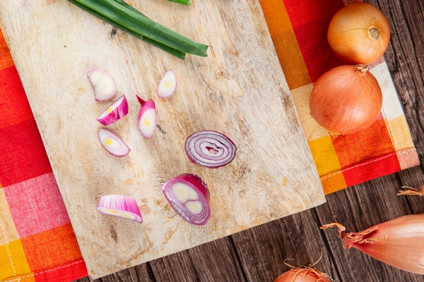 close up view of sliced red onion on wooden surface with yellow onions on wooden background - Постное "севиче" из цветной капусты