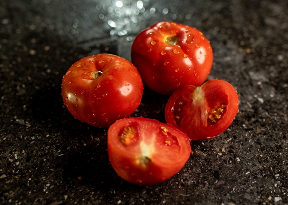 closeup of fresh ripe tomatoes with water droplets on a black granite kitchen counter surface 1 - Постное "севиче" из цветной капусты