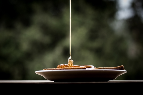 closeup shot of honey pouring on the bread slices on a plate - Монастырская кухня: вареники с яблоком и изюмом, морковное печенье