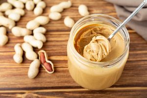 как едят арахисовую пасту и с чем в домашних условиях. creamy peanut paste in open glass jar peanut butter in spoon peanuts in the peel scattered on the brown wooden table. как едят арахисовую пасту и с чем в домашних условиях фото. как едят арахисовую пасту и с чем в домашних условиях-creamy peanut paste in open glass jar peanut butter in spoon peanuts in the peel scattered on the brown wooden table. картинка как едят арахисовую пасту и с чем в домашних условиях. картинка creamy peanut paste in open glass jar peanut butter in spoon peanuts in the peel scattered on the brown wooden table.