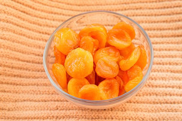 dried apricots in glass bowl on orange textile background healthy food and fruits - Монастырская кухня: голубцы из пекинской капусты, морковный цимес