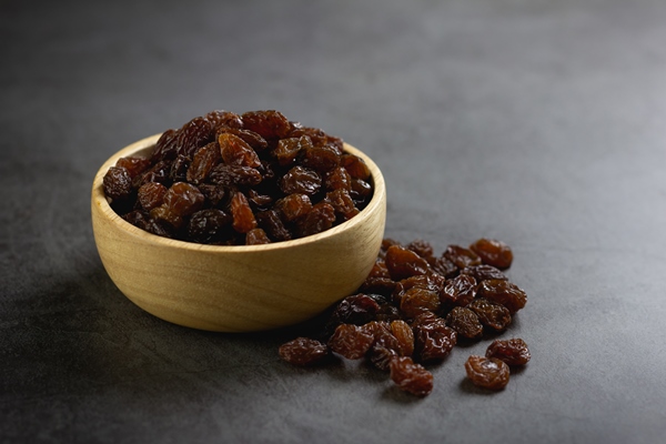 dried raisins in bowl on table - Овсянка с малиной и кешью без варки