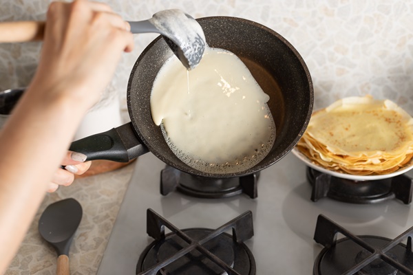 female hands cooking thin pancakes on frying pan - Блинный торт с заварным кремом