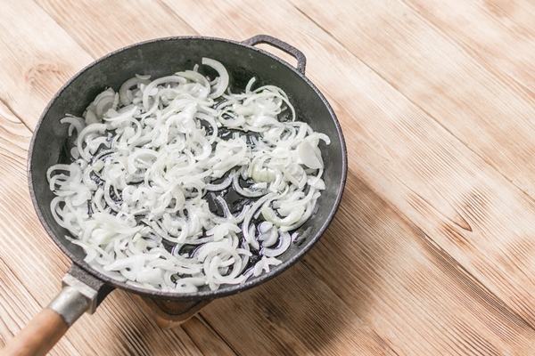 fried onions in a frying pan roasting the chopped onion in oil - Вырезка отбивная с луком