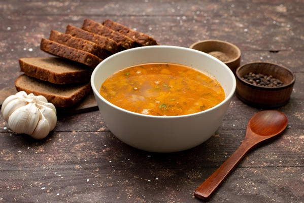 front view orange vegetable soup with bread loafs and garlic on brown food meal soup bread - Монастырская кухня: суп из кабачков, тёплый салат из чечевицы (видео)