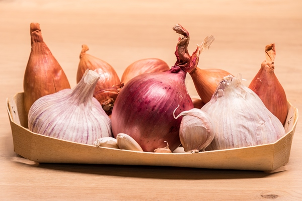 garlic onion shallots in a small wooden basket - Монастырская кухня: луковый суп с редькой, тыквенные оладьи (видео)
