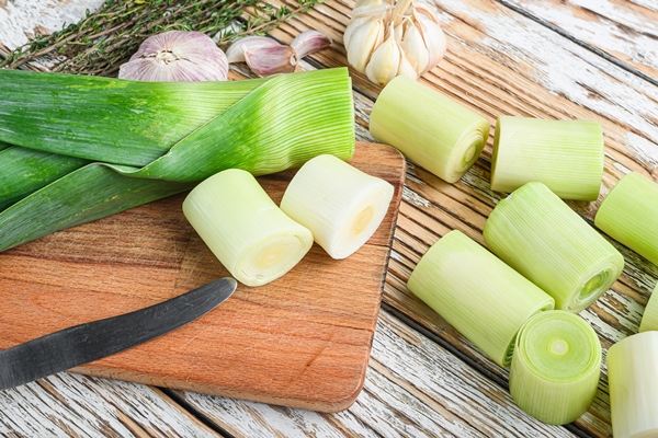 green chopped leek sultan on choppong board over white wood table - Монастырская кухня: смоленская каша с овощами, лимонный кисель (видео)