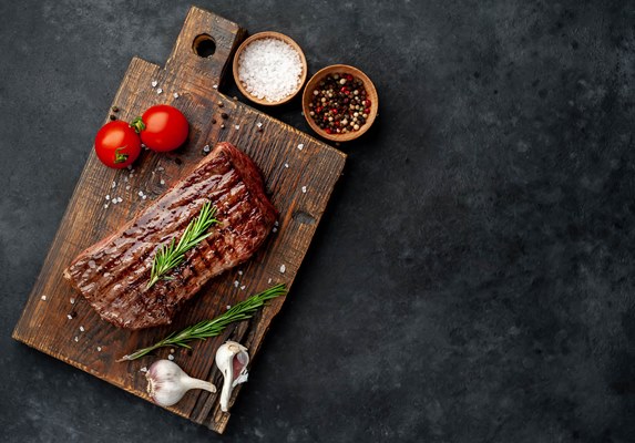 grilled beef steak wooden board with spices stone background with copy space your - Разновидности блюд из жареного мяса