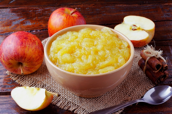 homemade apple sauce or apple puree in ceramic bowl over rustic wooden table top view - Овсянка с яблоком и корицей