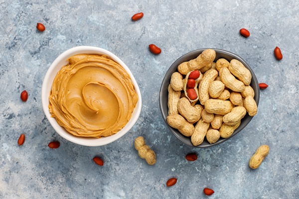 homemade peanut butter with peanuts on grey concrete table top view - Солёная арахисовая паста