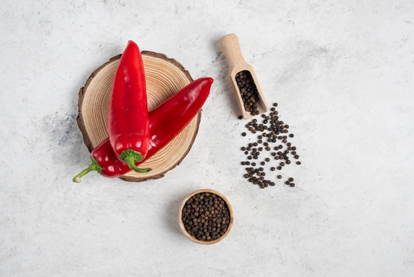 hot chili peppers and pepper grains on marble background - Соус фруктово-ягодный