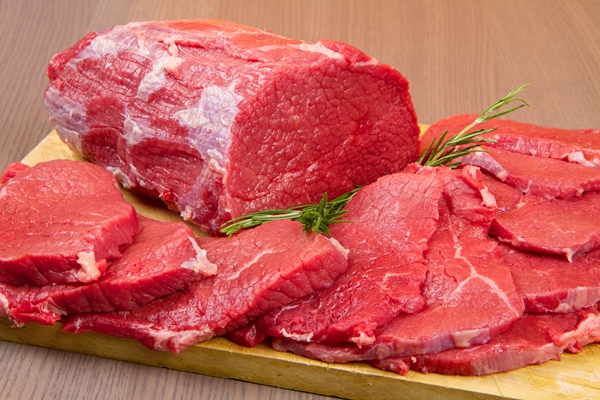 huge red meat chunk and steak on wood table - Вырезка отбивная с луком