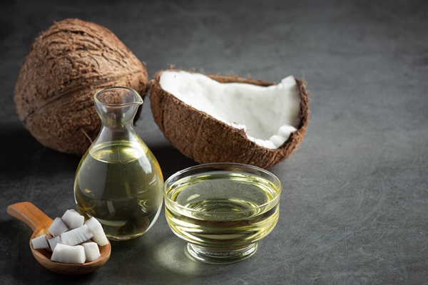 jug of coconut oil whit coconut put on dark background - Арахисовая паста с кокосом