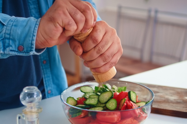 man pouring salt over healthy salad in kitchen for delicious meal cooking preparing healthy organic food happy together lifestyle cheerful meal in family with vegetables - Монастырская кухня: рыбный суп с кальмаром, запеканка с рыбой, салат овощной с винным уксусом