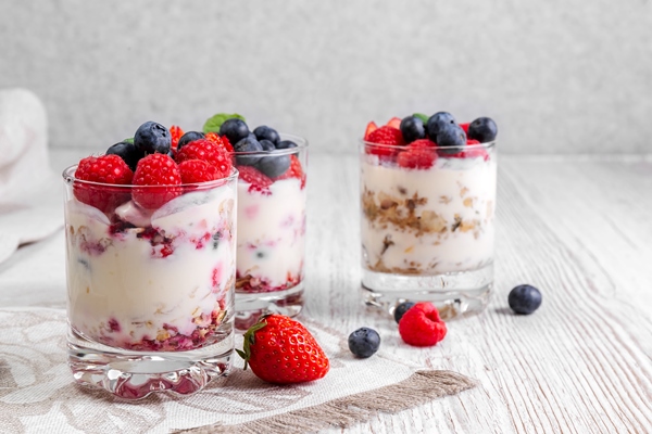 muesli with yogurt and berries in a glass on a white background - Каша на завтрак без варки