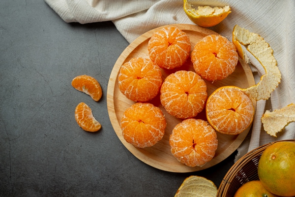 peeled tangerines on old dark background - Овсянка без варки с мандарином