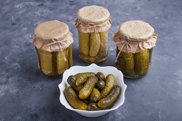 pickled cucumbers in bowl and glass jars on blue surface - Монастырская кухня: рассольник, постные блины с яблоками
