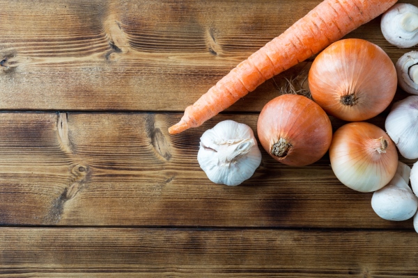 raw unpeeled onions champignons garlic and carrot on wooden dark table - Икра из шампиньонов