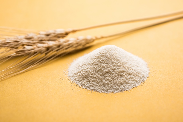 raw unprepared semolina flour also known as rava powder in hindi in bowl or spoon close up isolated on white or moody background selective focus - Монастырская кухня: манный мусс с клюквой и расстегаи