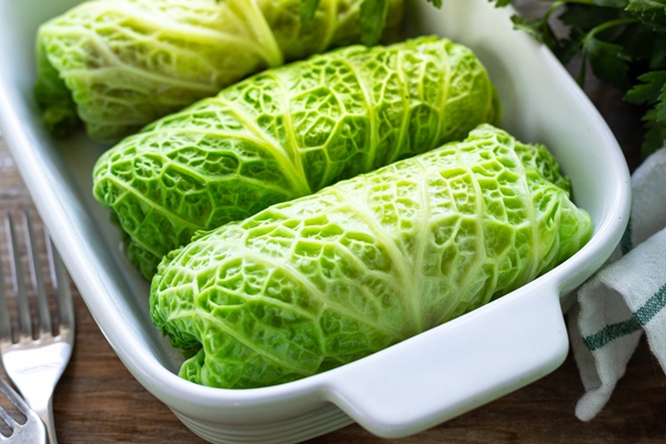 savoy cabbage rolls stuffed with meat rice and vegetables on a rustic table - Голубцы мясные