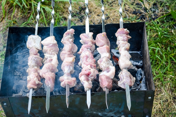 shish kebab on skewers marinated shashlik preparing on a barbecue grill over charcoal shashlik or shish kebab popular in eastern europe shashlik skewer meat was originally made of lamb - Шашлыки